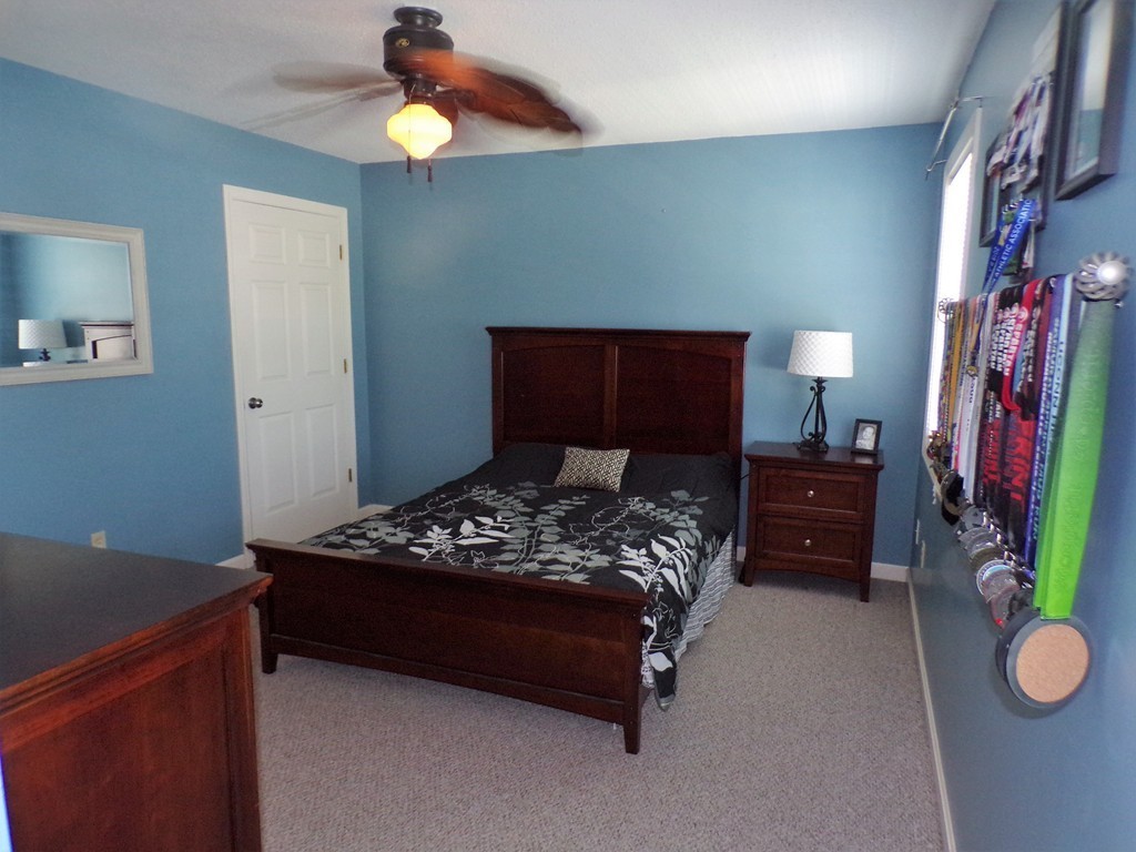 85 Belanger Street, Unit 85 Three Rivers, MA 01080 - Photo 8 of 16 a bedroom with a bed and a chandelier