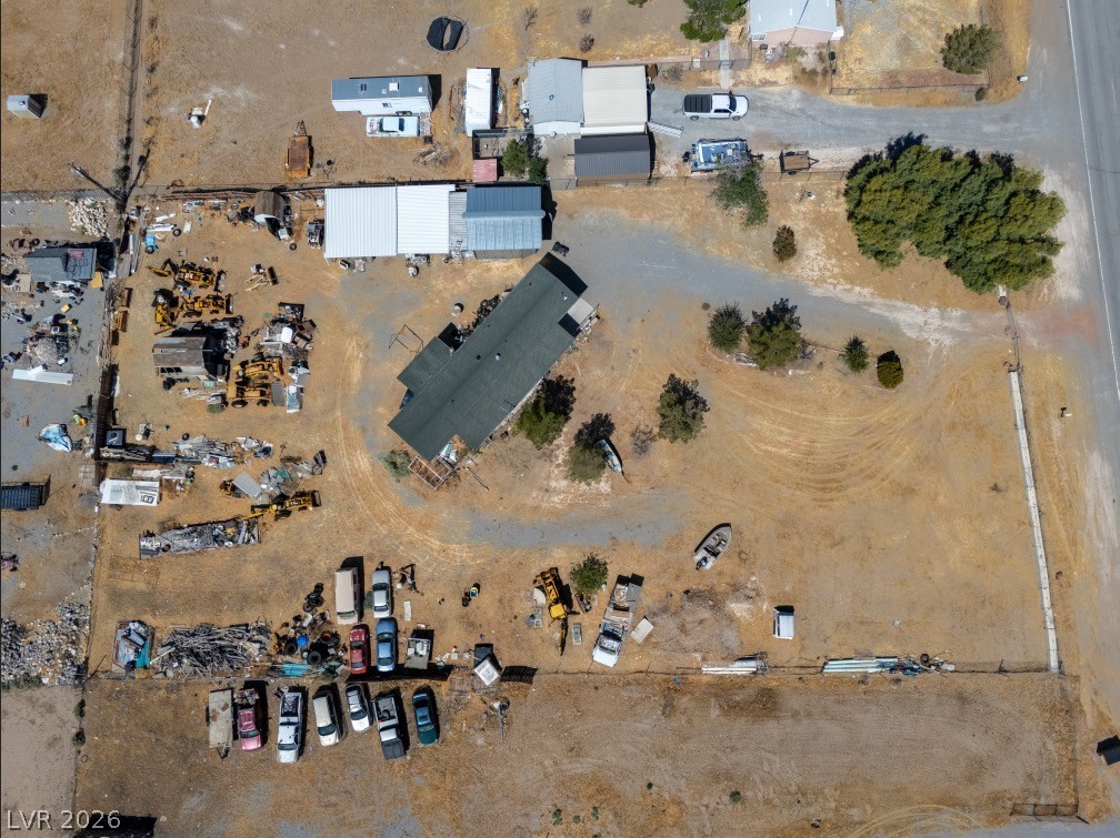 1301 East Manse Road Pahrump, NV 89048 - Photo 2 of 14 Aerial view showcasing a vast, sun-drenched lot with multiple structures and ample space.