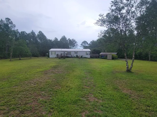 a view of a field with a house in the background