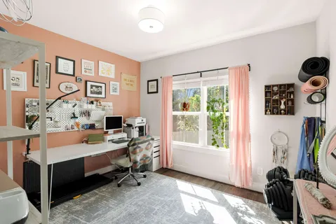 a view of a workspace with furniture and a window