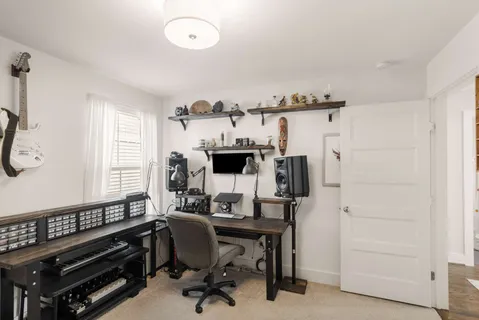 a view of a workspace with furniture and a window