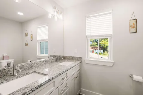 a bathroom with a granite countertop sink and a mirror