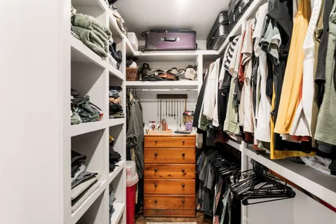 a view of walk in closet with clothes and shoes