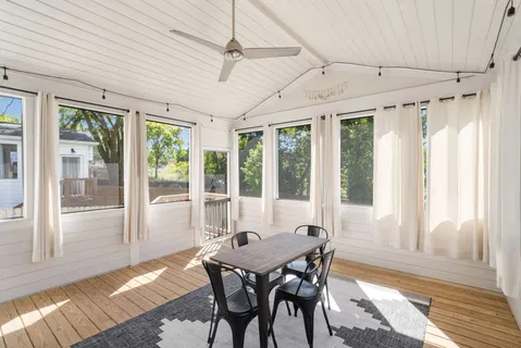 a view of a dining room with furniture large windows and wooden floor