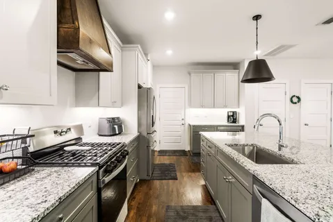 a kitchen with stainless steel appliances granite countertop a sink stove and refrigerator