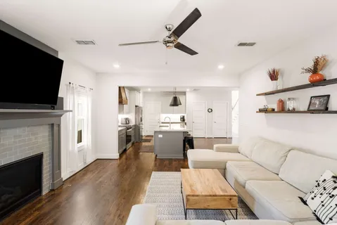 a living room with furniture a fireplace and a flat screen tv