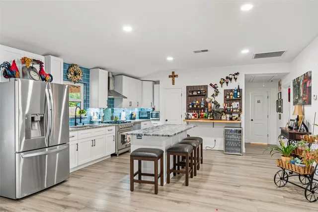 a kitchen with stainless steel appliances granite countertop a refrigerator and a stove top oven