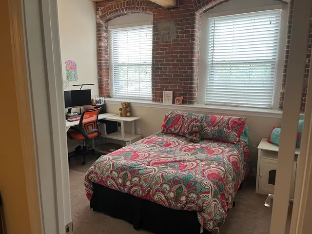 a bedroom with a bed and windows