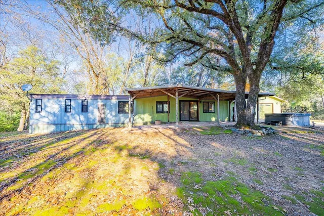 a view of a house with a yard and tree s