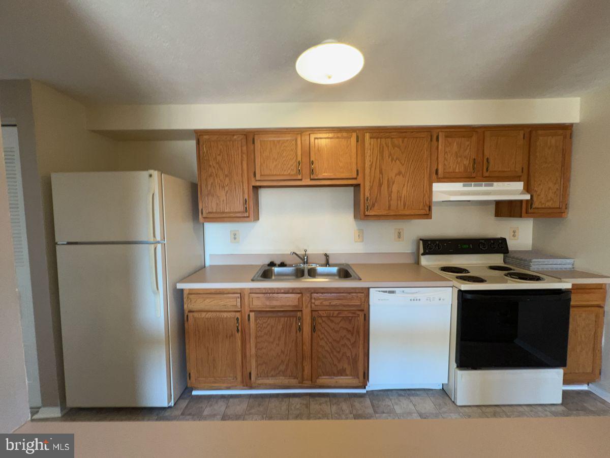 700 H Heather Ridge Drive, Unit 13H Frederick, MD 21702 - Photo 4 of 12 a kitchen with stainless steel appliances granite countertop a stove a refrigerator and a sink