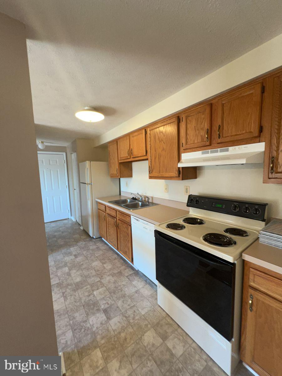 700 H Heather Ridge Drive, Unit 13H Frederick, MD 21702 - Photo 5 of 12 a kitchen with a stove a sink and a refrigerator
