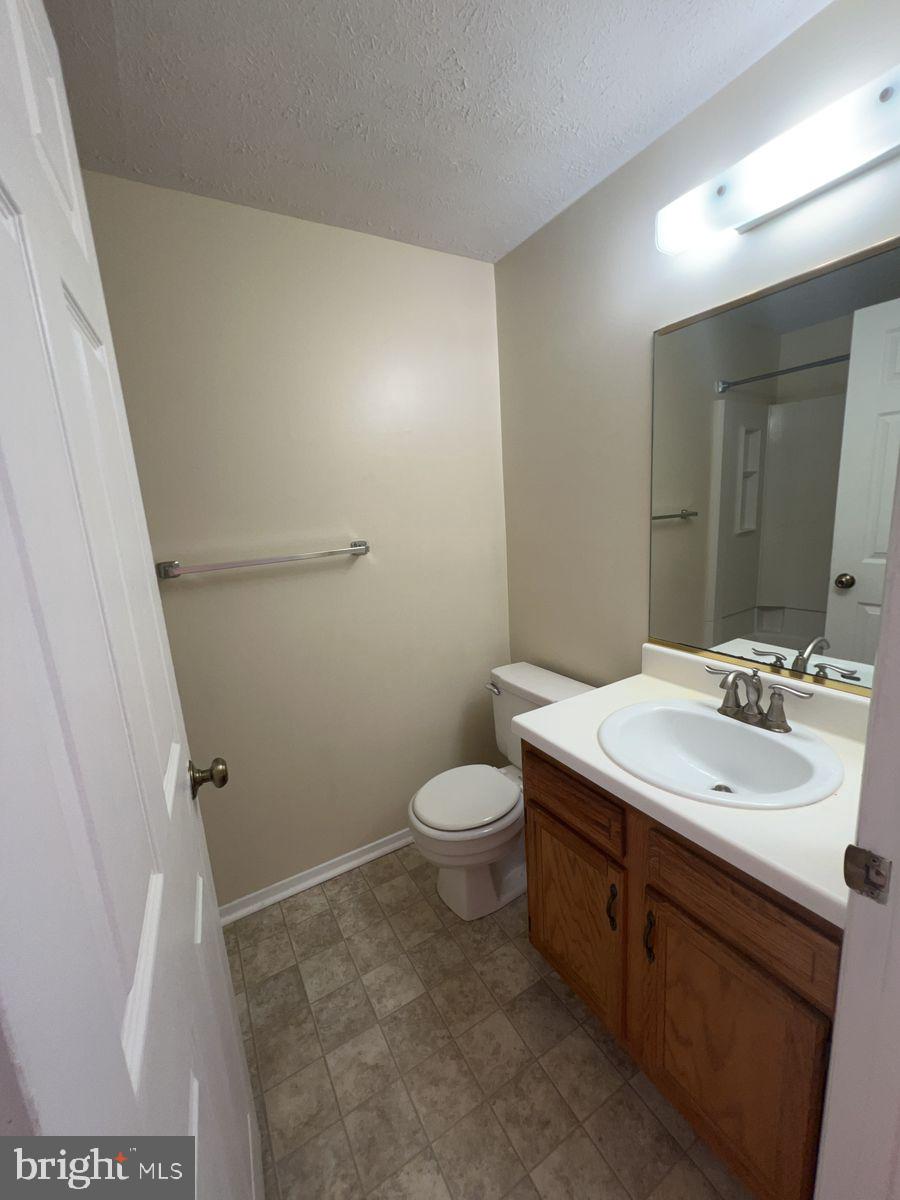 700 H Heather Ridge Drive, Unit 13H Frederick, MD 21702 - Photo 10 of 12 a bathroom with a sink a toilet a mirror and vanity