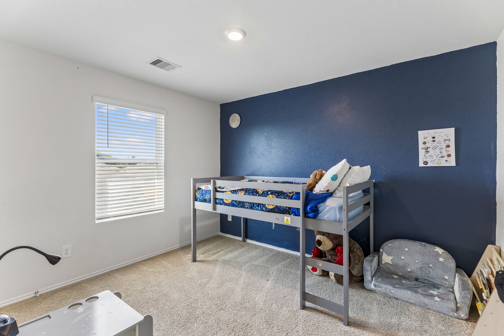343 Sickle Loop Kyle, TX 78640 - Photo 28 of 40 Bright room featuring a window with horizontal blinds, neutral carpet flooring, and a contrasting accent wall