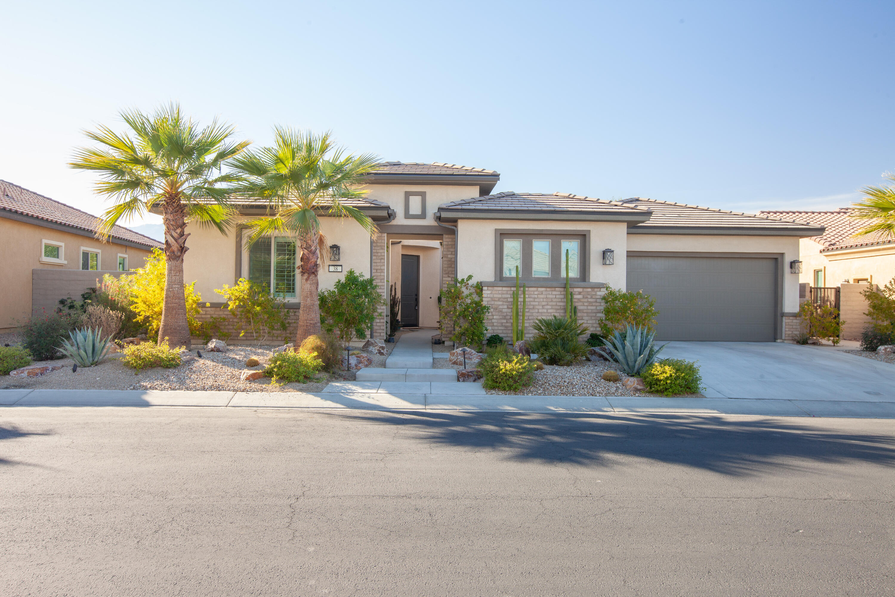 a view of a house with a outdoor space and palm trees