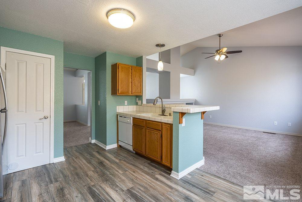 3943 Regal Drive Reno, NV 89503 - Photo 12 of 29 a kitchen with stainless steel appliances granite countertop a sink a stove a refrigerator and island with wooden floor