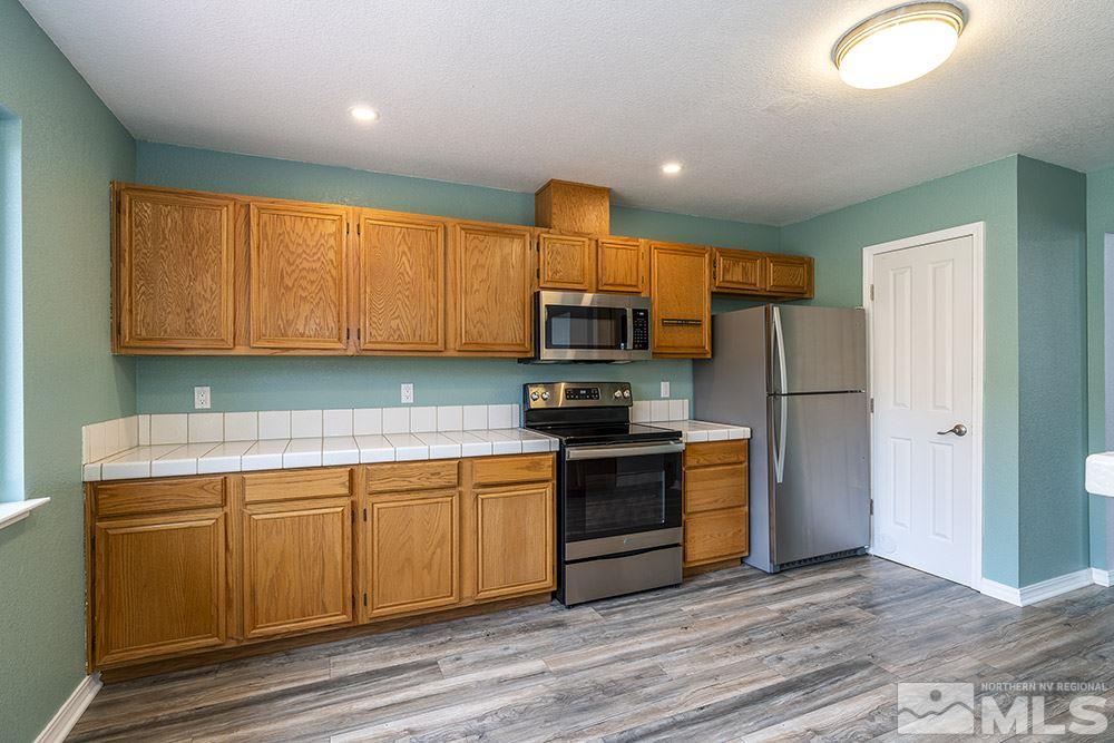 3943 Regal Drive Reno, NV 89503 - Photo 13 of 29 a kitchen with stainless steel appliances granite countertop a stove top oven a refrigerator and a sink with granite countertops