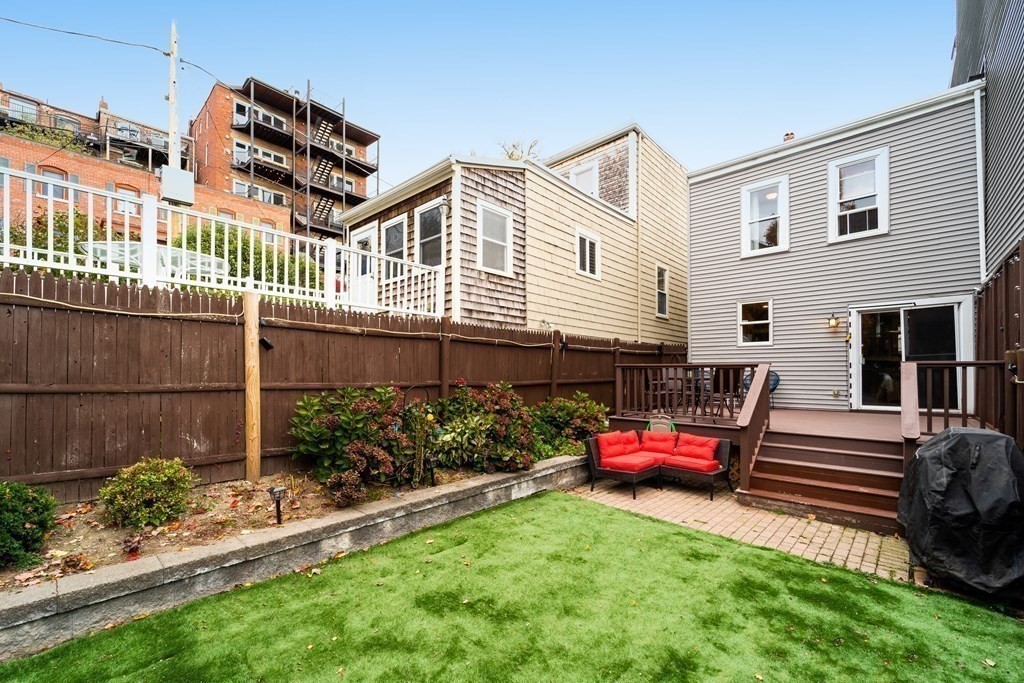 32 Covington Street, Unit SF Boston, MA 02127 - Photo 25 of 27 a backyard of a house with barbeque oven table and chairs