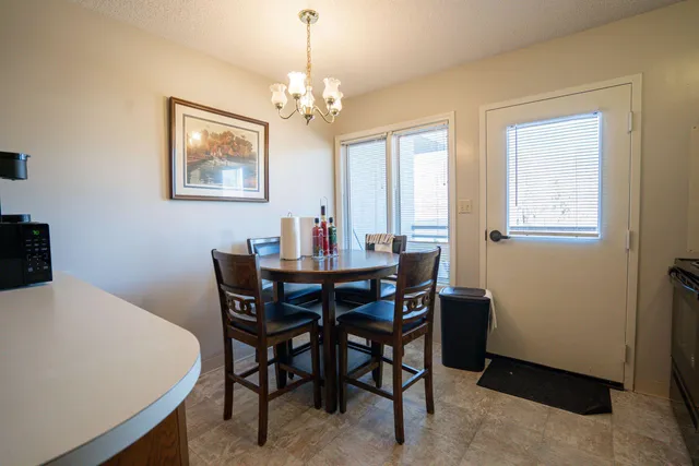 a view of a dining room with furniture and chandelier