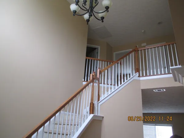 a view of staircase with railing and white walls