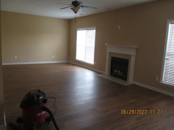 a living room with hard wood floors and a fireplace