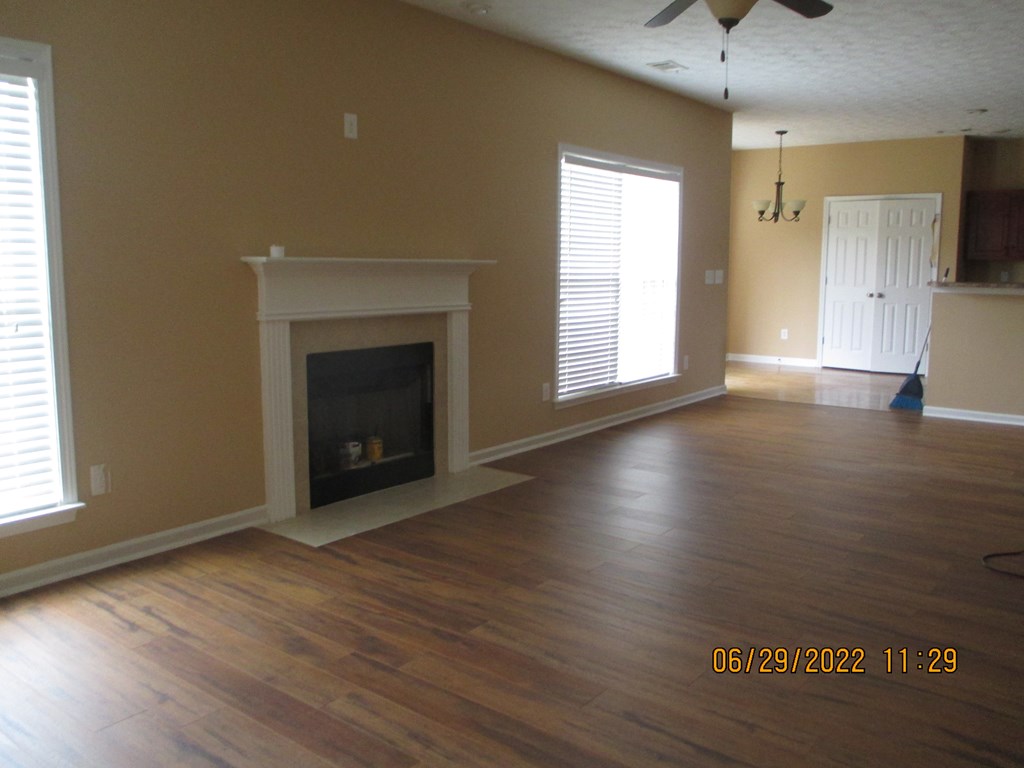 9012 Sante Fe Court Columbus, GA 31909 - Photo 7 of 16 an empty room with wooden floor fireplace and windows
