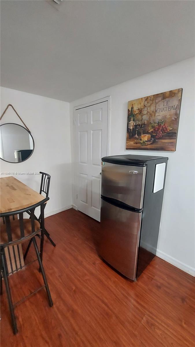 825 Brickell Bay Drive, Unit 443 Miami, FL 33131 - Photo 1 of 26 a view of workspace room with wooden floor and furniture