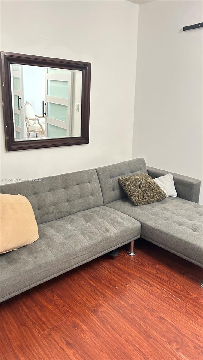 825 Brickell Bay Drive, Unit 443 Miami, FL 33131 - Photo 18 of 26 a living room with a couch and wooden floor
