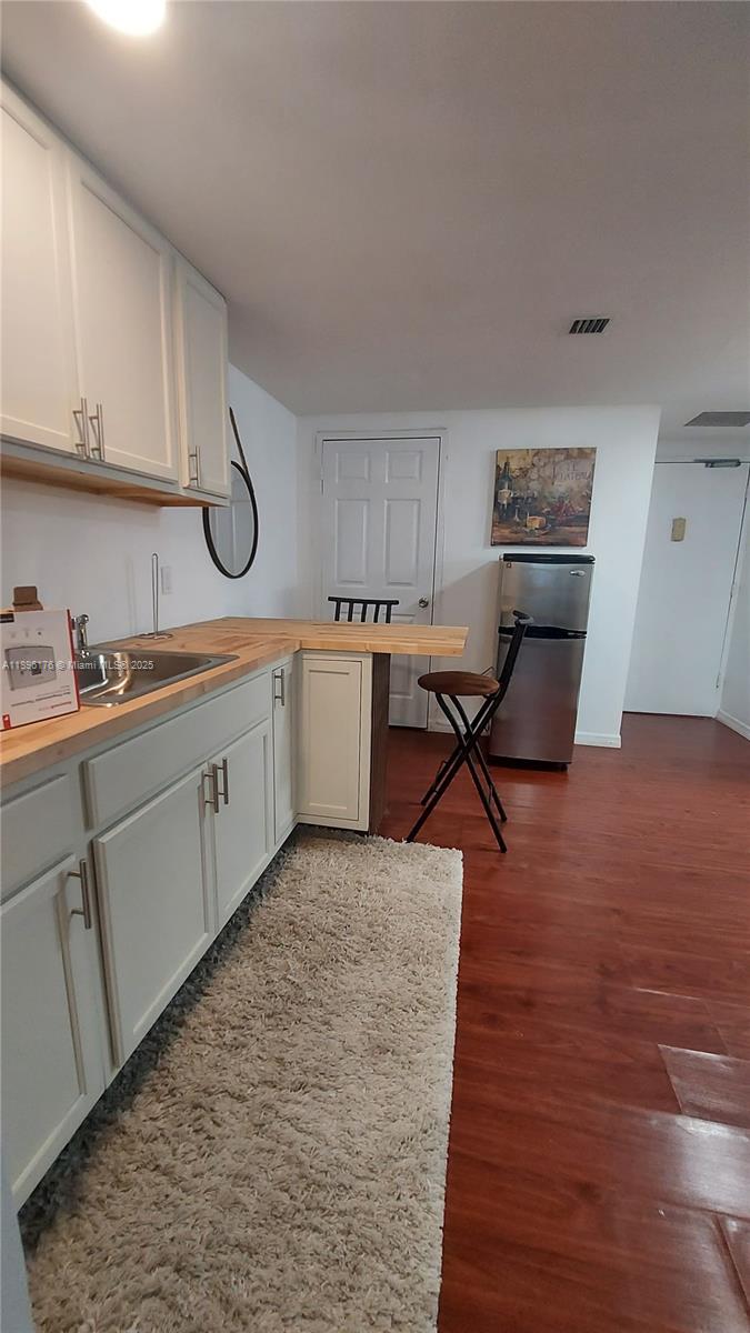 825 Brickell Bay Drive, Unit 443 Miami, FL 33131 - Photo 3 of 26 a kitchen with stainless steel appliances granite countertop a stove top oven a sink dishwasher and cabinets with wooden floor