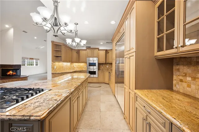 a kitchen with kitchen island granite countertop a sink a counter top space and stainless steel appliances
