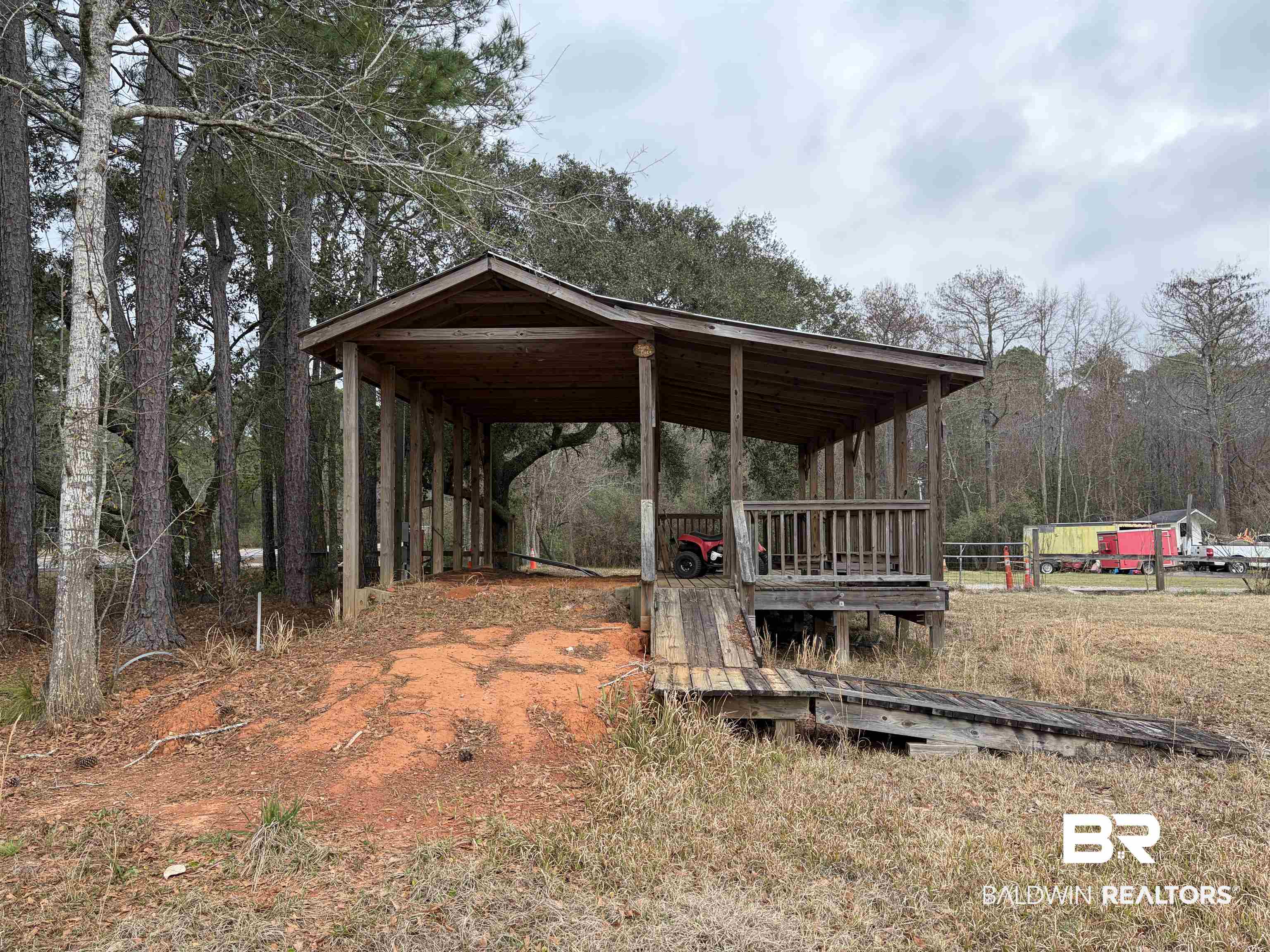 10585 Bellingrath Road Theodore, AL 36582 - Photo 4 of 14 Exterior space with a carport, a wooden deck, and a forest view