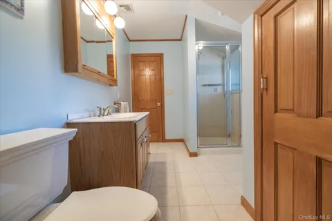 a bathroom with a sink a toilet a mirror and shower