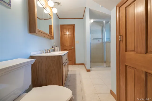 a bathroom with a sink a toilet a mirror and shower