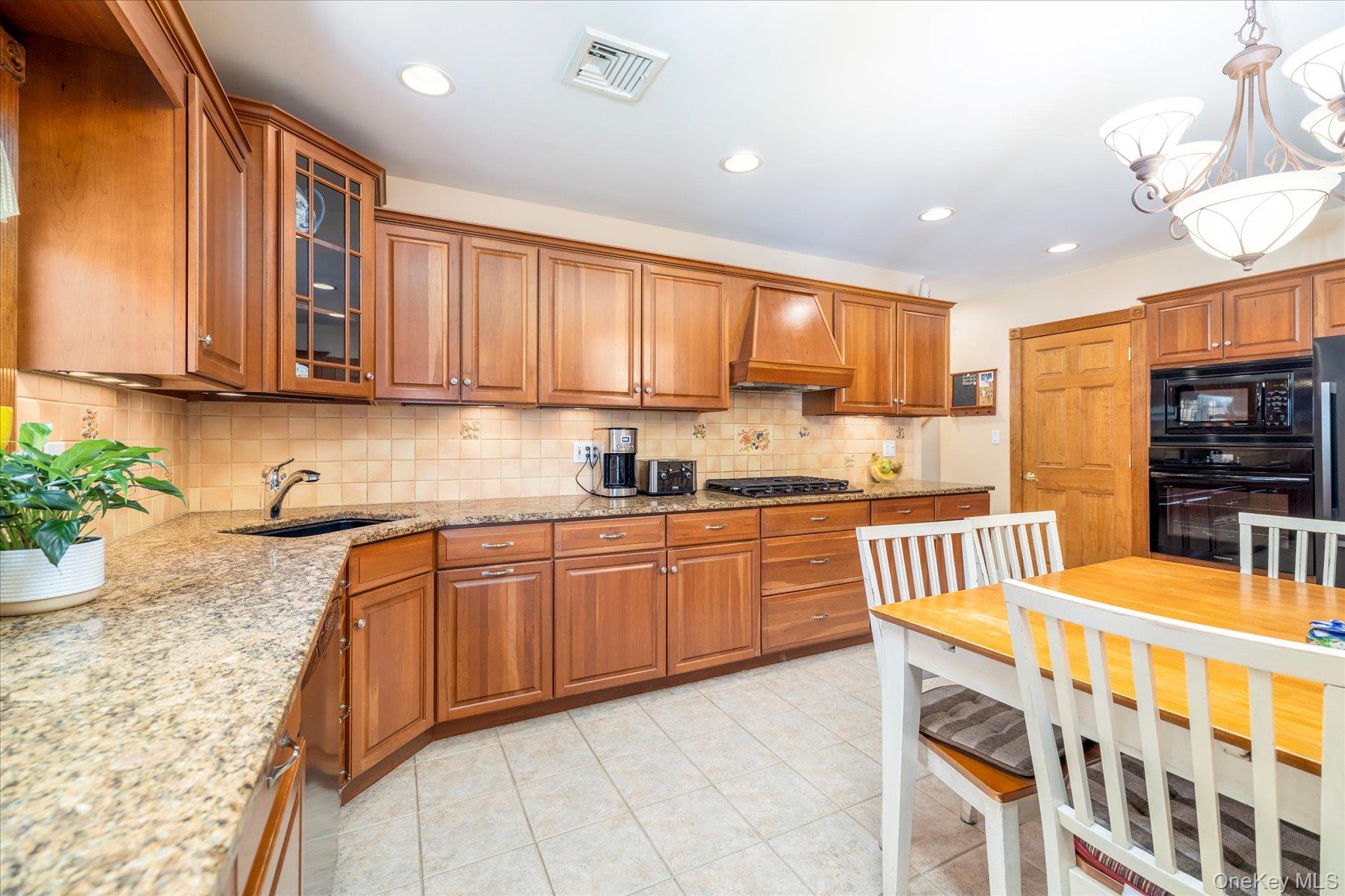 15 Baylis Road Rockville Centre, NY 11570 - Photo 3 of 20 a kitchen with stainless steel appliances granite countertop a stove a sink and a refrigerator