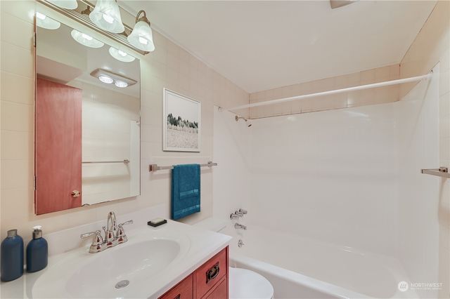 a bathroom with a bathtub shower sink vanity and a mirror