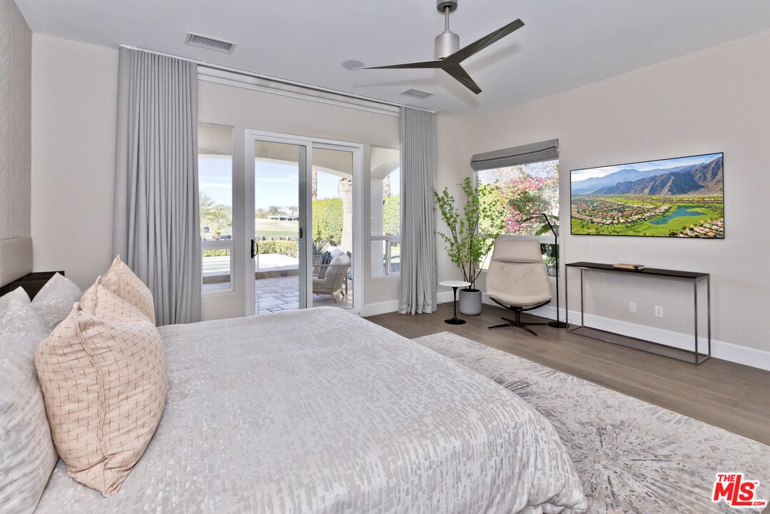 380 Loch Lomond Road Rancho Mirage, CA 92270 - Photo 15 of 39 a spacious bedroom with a bed and a chandelier