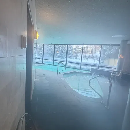 a view of an empty room with wooden floor and glass door