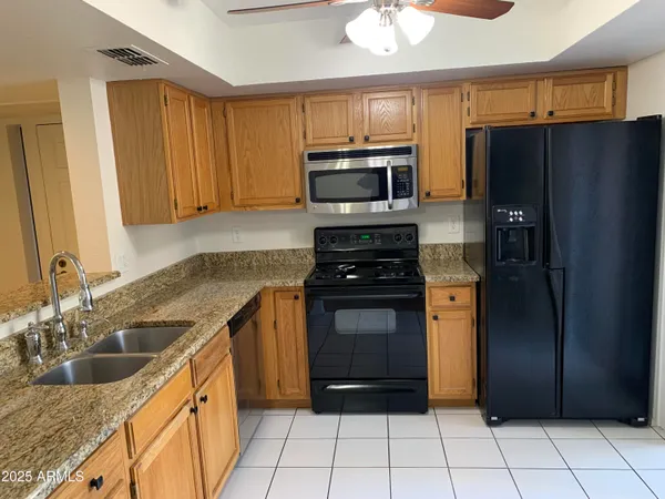 a kitchen with granite countertop a refrigerator and a sink