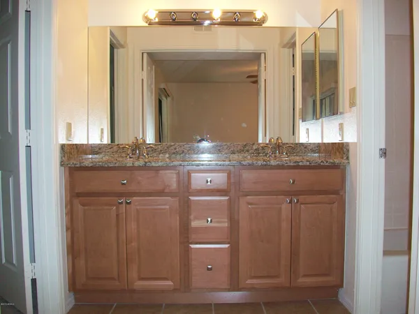 a bathroom with a granite countertop sink and a mirror
