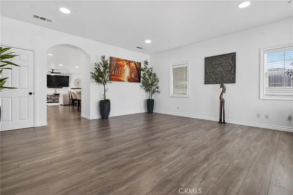 a view of a living room a dining room wooden floor and a flat screen tv