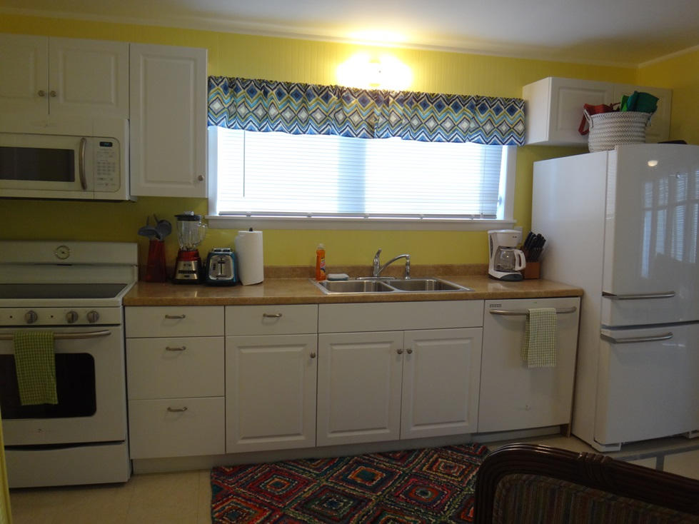 53 Barry Avenue Summerland Key, FL 33042 - Photo 9 of 22 a kitchen with white cabinets and window