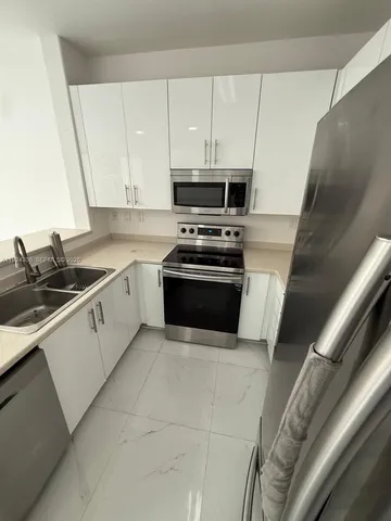 a kitchen with stainless steel appliances granite countertop a sink and a stove