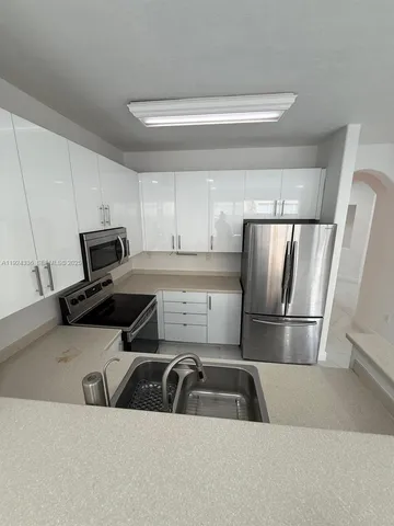 a view of kitchen with furniture and a refrigerator