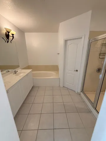 a bathroom with a tub sink and mirror