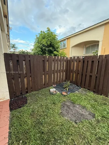 a view of a backyard with wooden fence