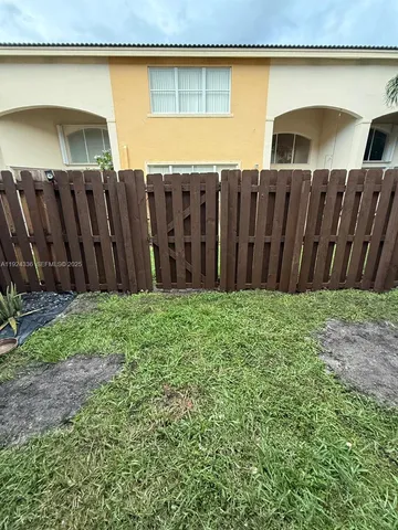 a view of a backyard with wooden fence