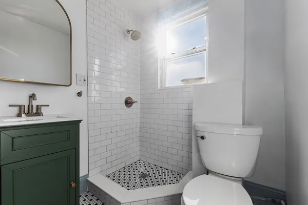 a bathroom with a toilet a sink and mirror