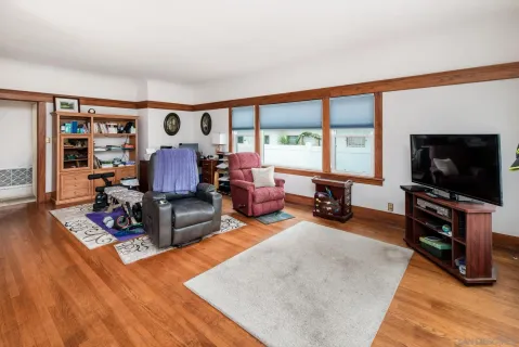 a living room with furniture a flat screen tv and a large window