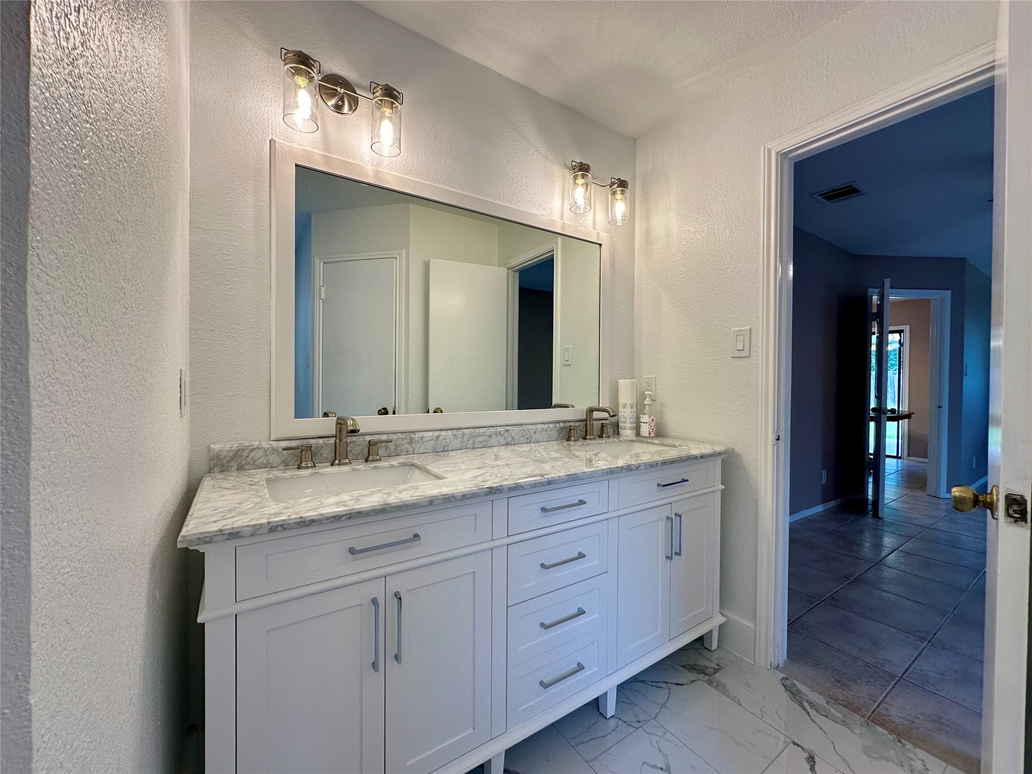 709 Brookside Pass Cedar Park, TX 78613 - Photo 9 of 10 Bathroom featuring a dual vanity with a marble countertop, white shaker style cabinetry, and brushed nickel hardware