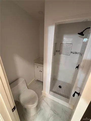 a bathroom with a toilet and a shower