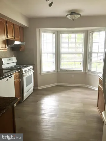 a view of a kitchen with a sink dishwasher and wooden floor